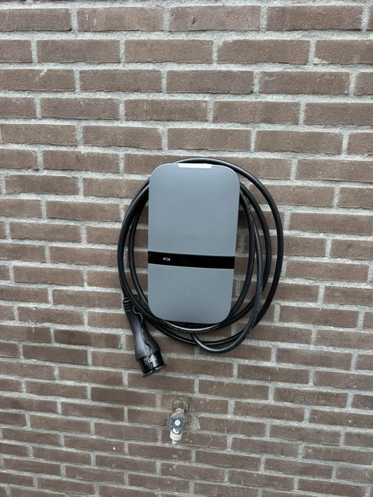 Peblar-laadpaal met vaste laadkabel aan een buitenmuur