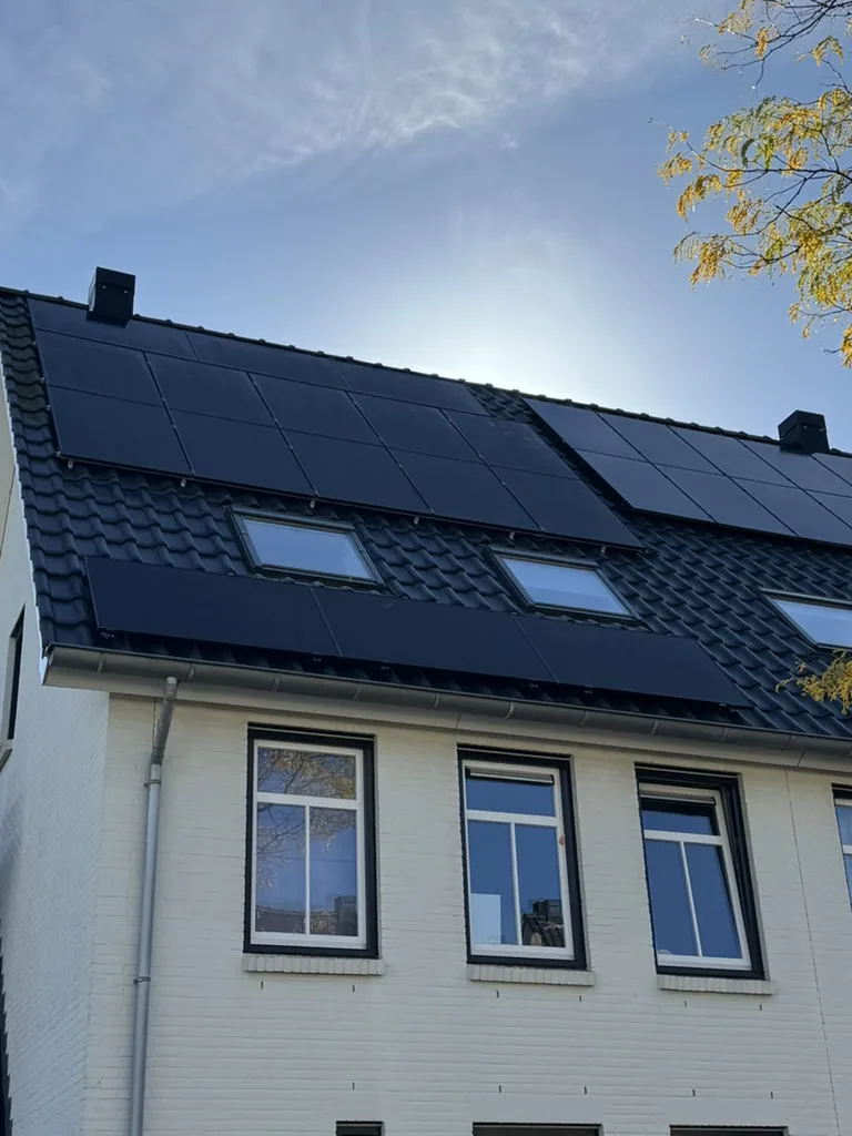 Zwarte zonnepanelen op een pannendak rond dakramen